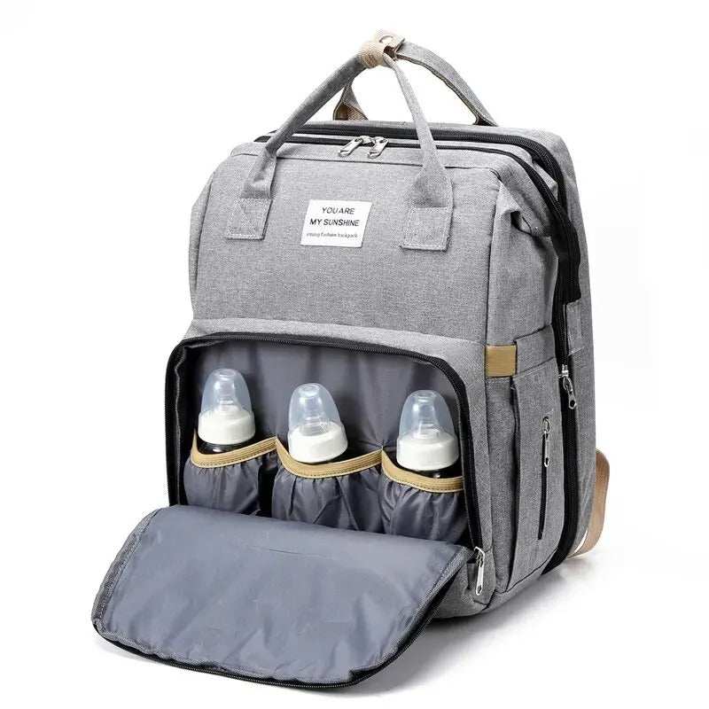 Sac à dos pratique Sac à dos pratique gris en tissu, avec compartiment isotherme ouvert pour trois biberons et rabat matelassé